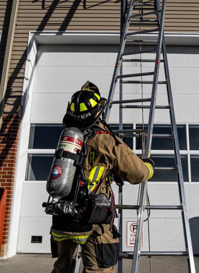 Firefighter holding a ladder